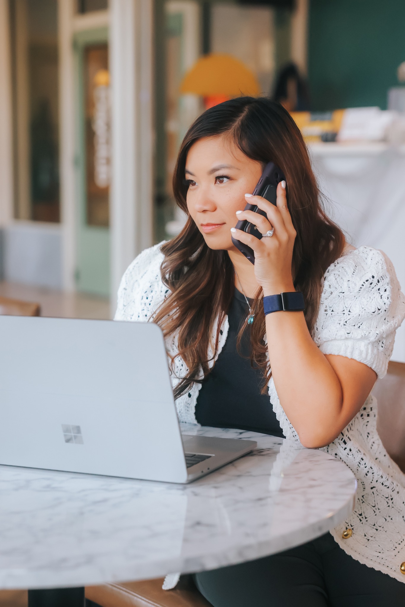 Natalie Nguyen on the phone beside her laptop
