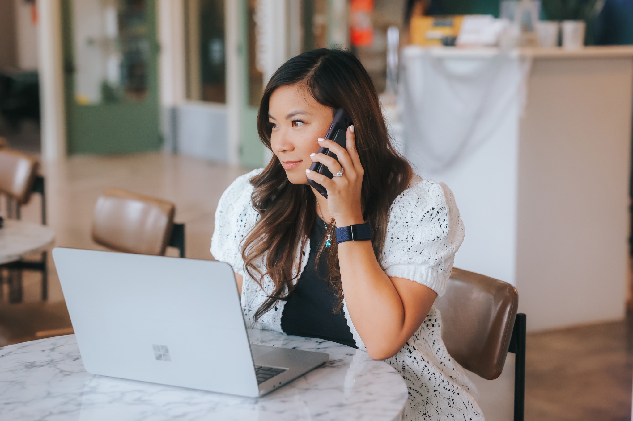 Natalie Nguyen on the phone beside her laptop